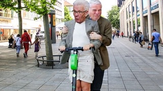 Kretschmann und Strobl zusammen auf einem E-Scooter
