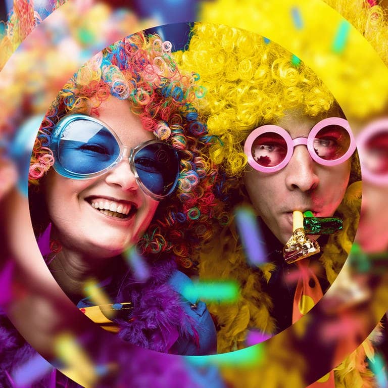 Zwei feiernde Menschen mit bunten Perrücken und Sonnenbrillen (Foto: Adobe Stock, karepa)