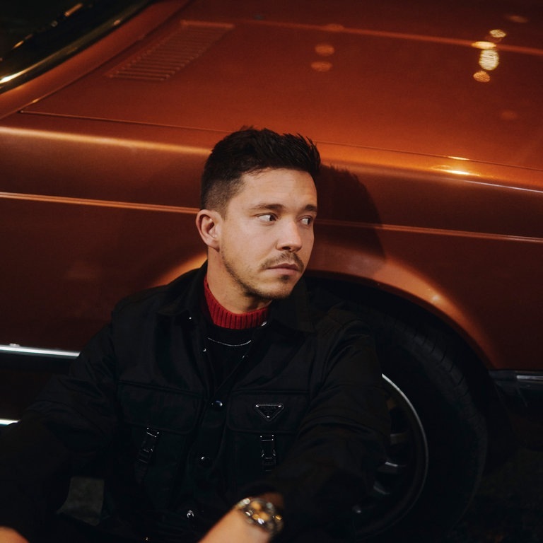 Der Sänger Nico Santos sitzt vo einem Auto (Foto: Christoph Köstlin)