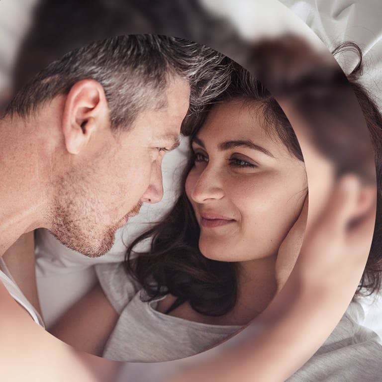 Junges Paar kuschelt verliebt im Bett
