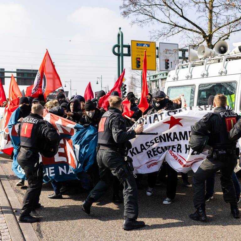 Polizisten schlagen mit Schlagstöcken auf Demonstranten ein, um den Demonstrationszug gegen den Landesparteitag der AfD Baden-Württemberg zu stoppen