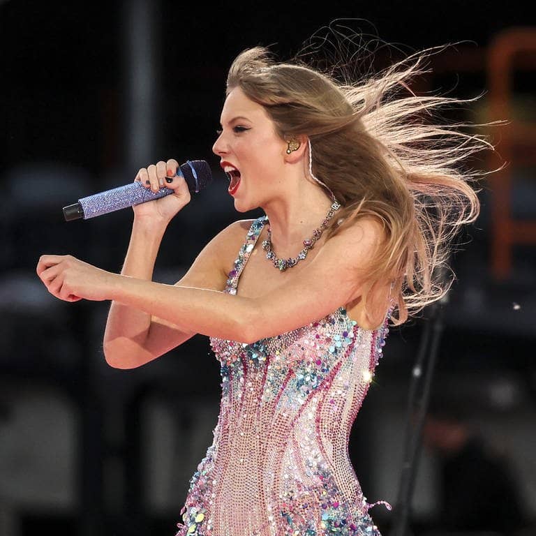 Taylor Swift tritt in Chicago im Rahmen der Eras Tour auf. Sie steht auf der Bühne in einem glitzernden kurzen Kleid.