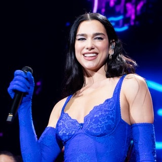 Dua Lipa 2022 auf der Bühne in Australien in einem blauen Ganzkörperdress.
