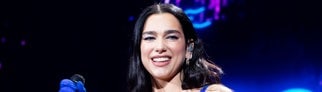 Dua Lipa 2022 in Australien in einem blauen Ganzkörperdress. Bei ihrem Konzert in Melbourne 2025 übergibt sie einem Fan einen USB-Stick.