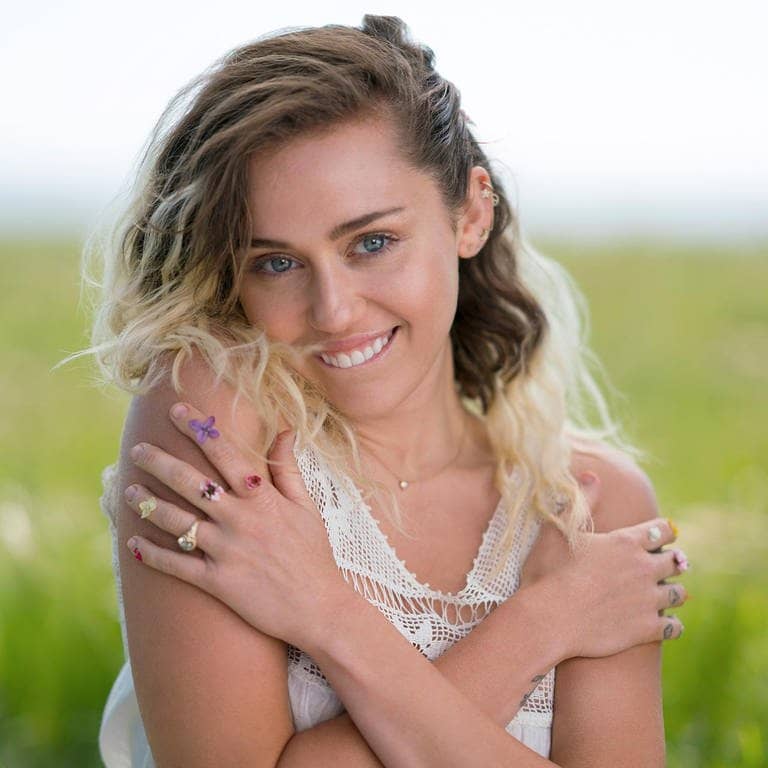 „Flowers“-Sängerin Miley Cyrus steht auf einer Blumenwiese