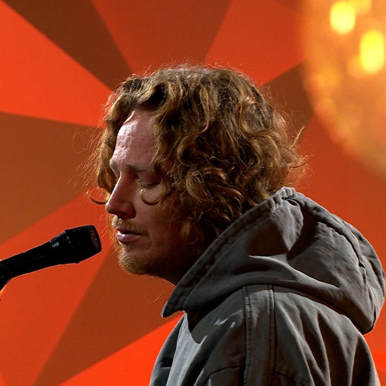 Der Sänger Michael Schulte singt im Schein einer Lampe