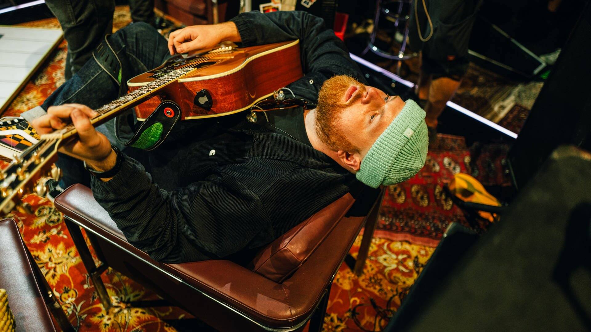 Tom Walker liegt in einem Stuhl, spielt Gitarre und guckt an die Decke (Foto: SWR3, Niko Neithardt)