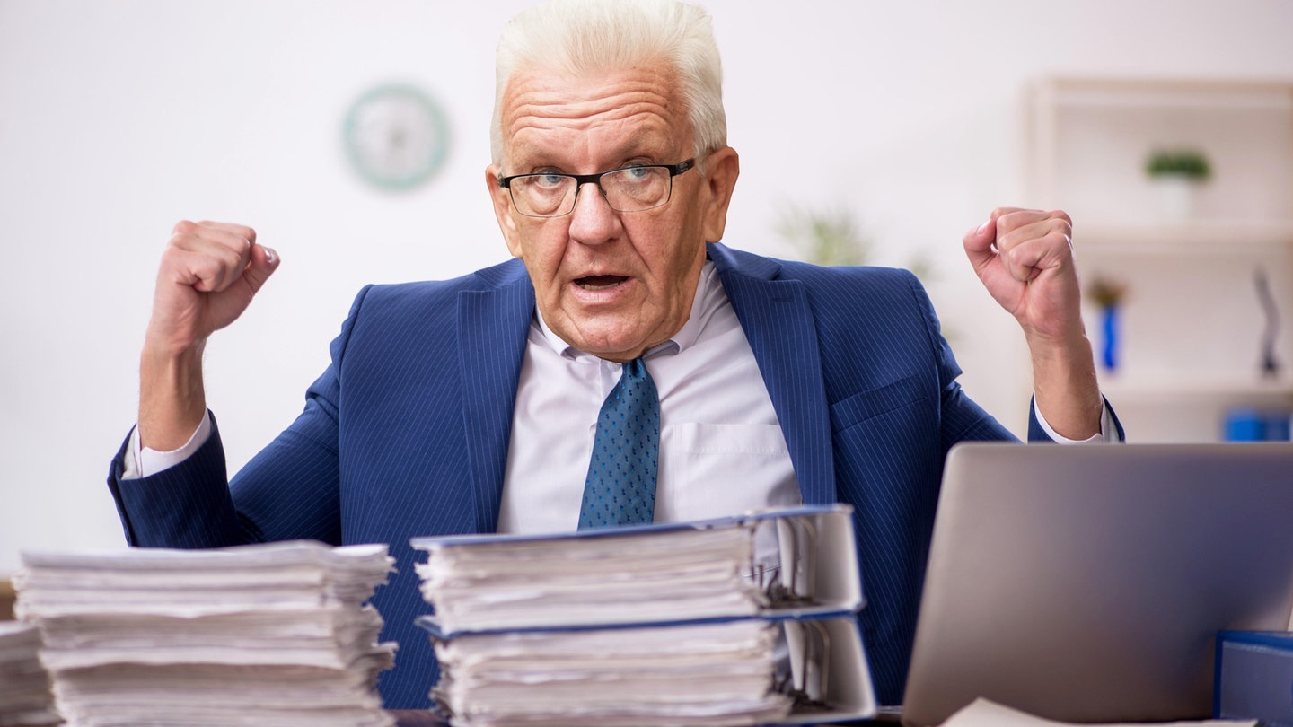 Foto: picture-alliance / Reportdienste, Elnur Amikishiyev; Marijan Murat Winfried Kretschmann sitzt hinter Papierstapeln am Tisch (Foto: picture-alliance / Reportdienste, Elnur Amikishiyev; Marijan Murat)