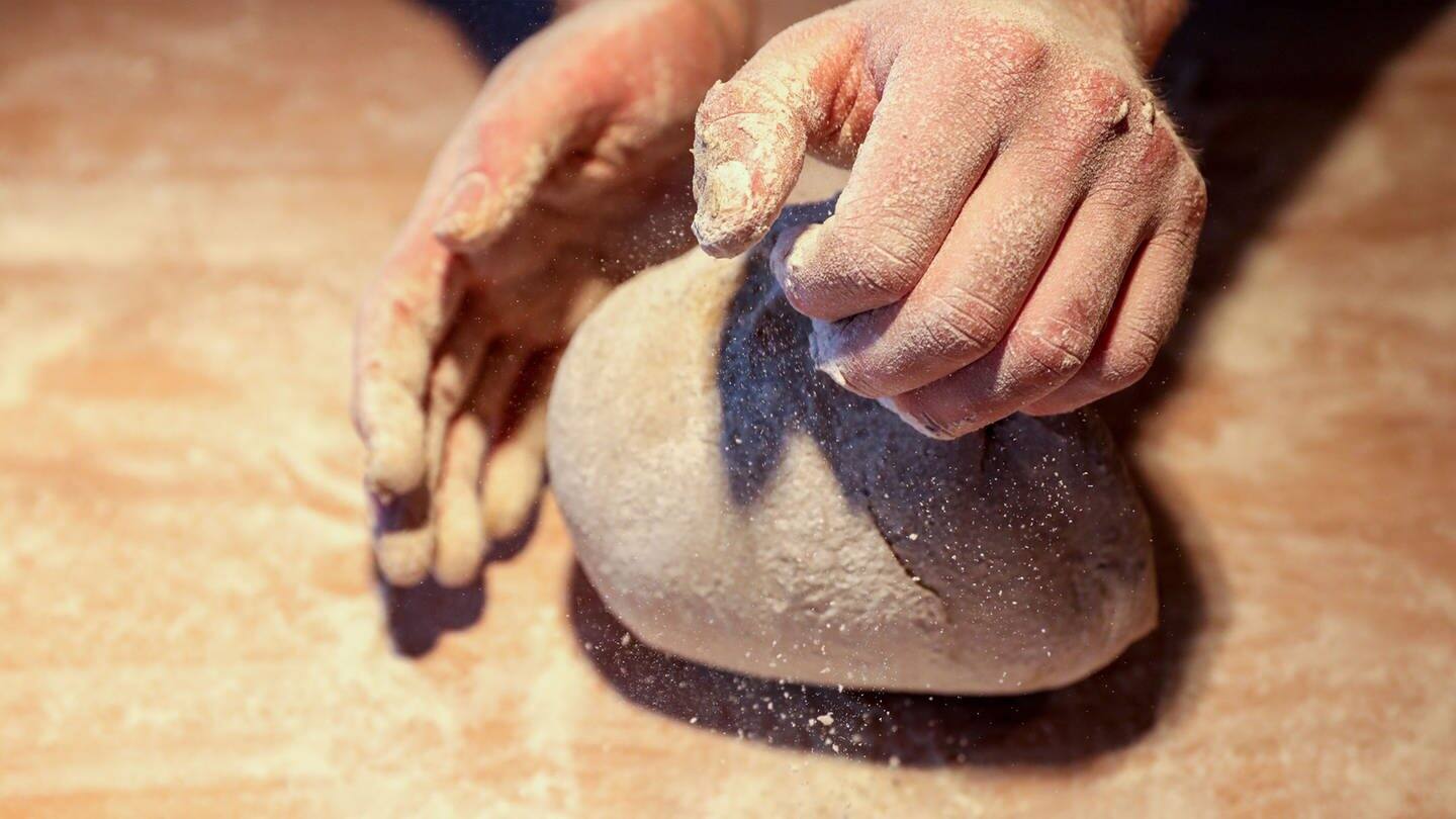Ein Bäcker formt mit seinen Händen ein Brot (Foto: picture-alliance / Reportdienste, Jan Woitas)