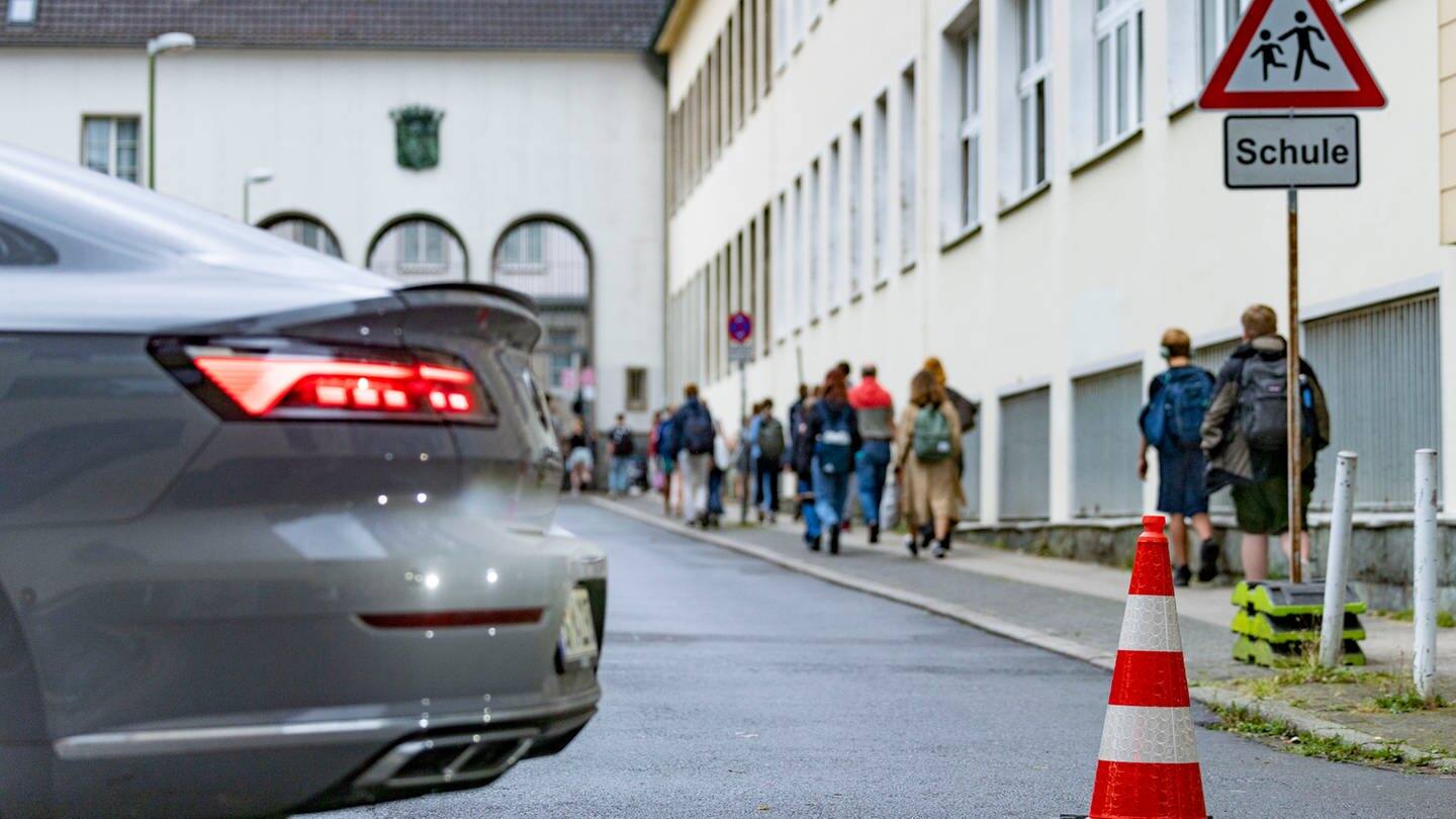 Pylonen und ein Auto stehen auf der Straße vor einer Schule (Foto: picture-alliance / Reportdienste, Christoph Reichwein)