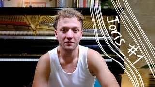 Joris Portrait Bild vor Klavier auf grünem Stuhl