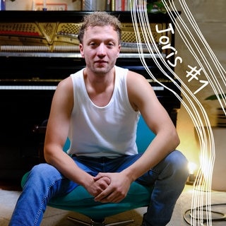 Joris Portrait Bild vor Klavier auf grünem Stuhl
