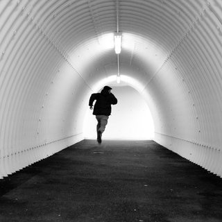flüchtender junger Mann in einem Tunnel in schwarz-weiß gehalten