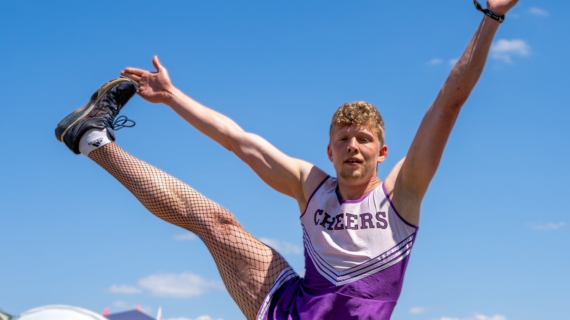 Foto: SWR3, SWR3 / Ronny Krautz Ein junger Mann hat ein lila Cheerleader-Köstüm an und streckt sein Bein seitlich in die Höhe (Foto: SWR3, SWR3 / Ronny Krautz)