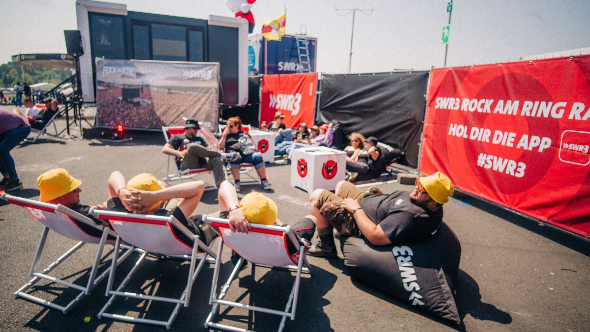 Foto: SWR3, SWR3 / Niko Neithardt Einige Besucher von Rock am Ring ruhen sich in Liegestühlen von SWR3 aus (Foto: SWR3, SWR3 / Niko Neithardt)