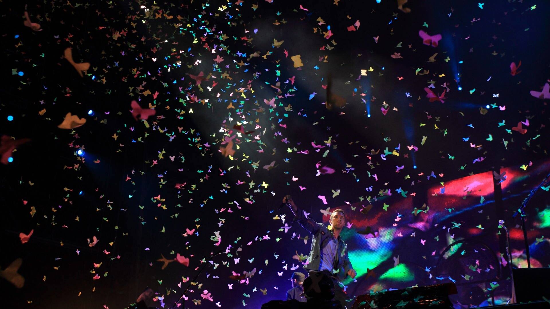 Chris Martin von Coldplay steht auf der Bühne, während Konfetti auf ihn regnet. (Foto: IMAGO, picture-alliance / Reportdienste, Thomas Frey)