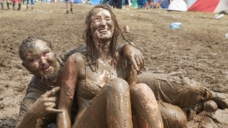 Ein Mann und eine Frau wälzen sich beim Musikfestival Rock am Ring im Schlamm. (Foto: picture-alliance / Reportdienste, Thomas Frey) Ein Mann und eine Frau wälzen sich beim Musikfestival Rock am Ring im Schlamm.