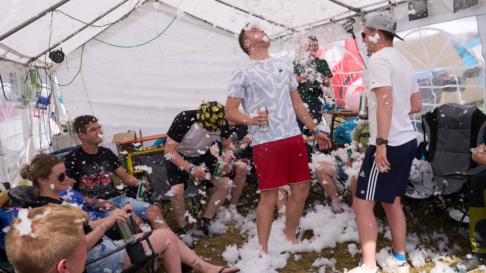 Festivalbesucher sitzen auf dem Campingplatz in einem Zelt und nutzen eine Schneemaschine. (Foto: picture-alliance / Reportdienste, Thomas Frey)