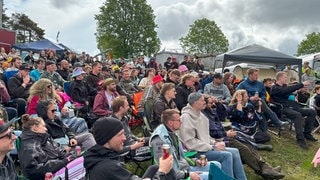 Viele Menschen sitzen auf Campingstühlen auf dem Campingplatz bei Rock am Ring und hören bei der Biermesse zu. (Foto: SWR3) Viele Menschen sitzen auf Campingstühlen auf dem Campingplatz bei Rock am Ring und hören bei der Biermesse zu.