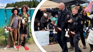 Auf dem Campingplatz bei Rock am Ring reiten zwei Polizisten in Uniform auf einem Steckenpferd.