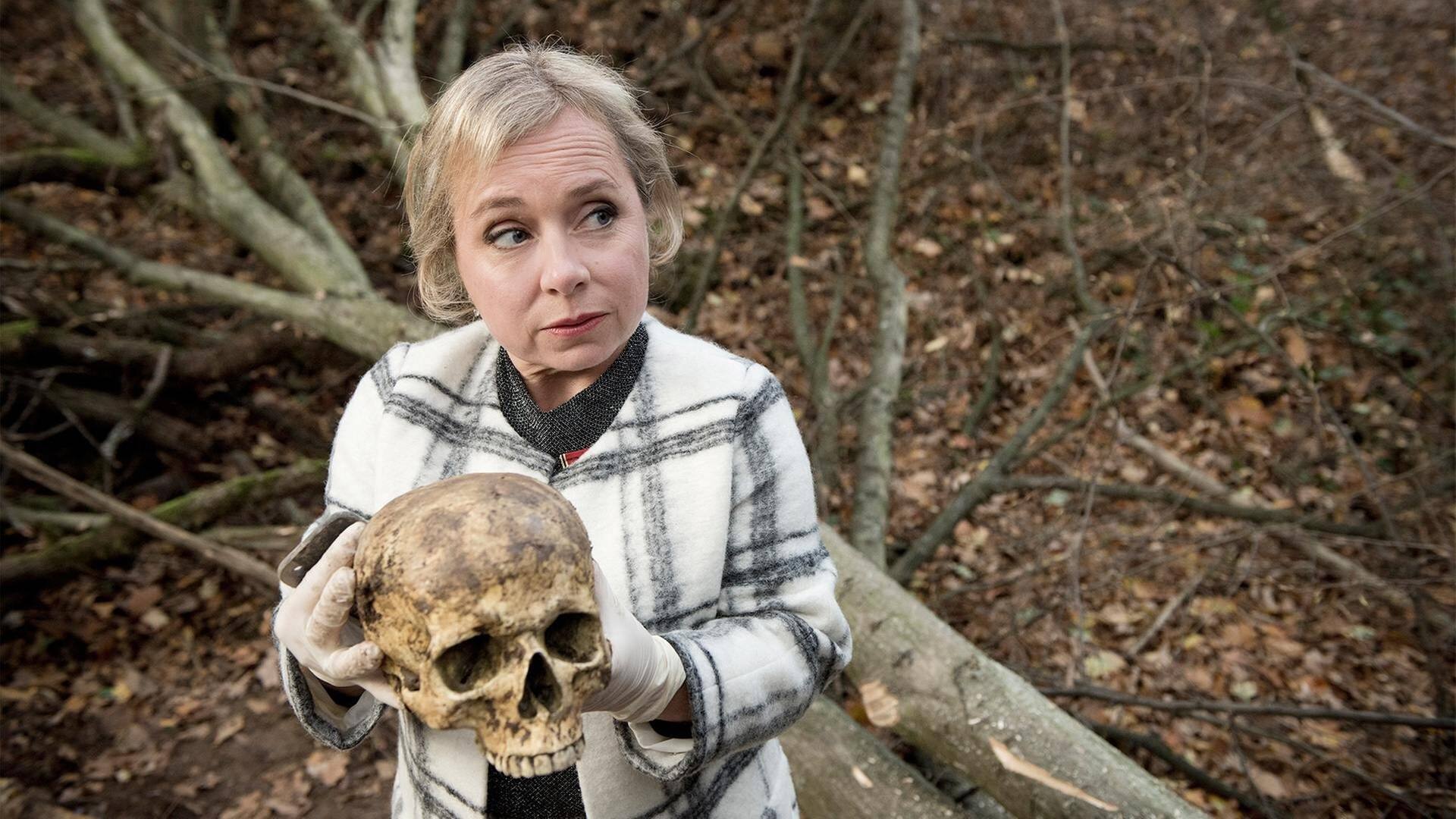 Silke Haller (Christine Urspruch) mit dem Schädel, den Arbeiter im Wolbecker Wald gefunden haben. (Foto: WDR/Martin Menke)