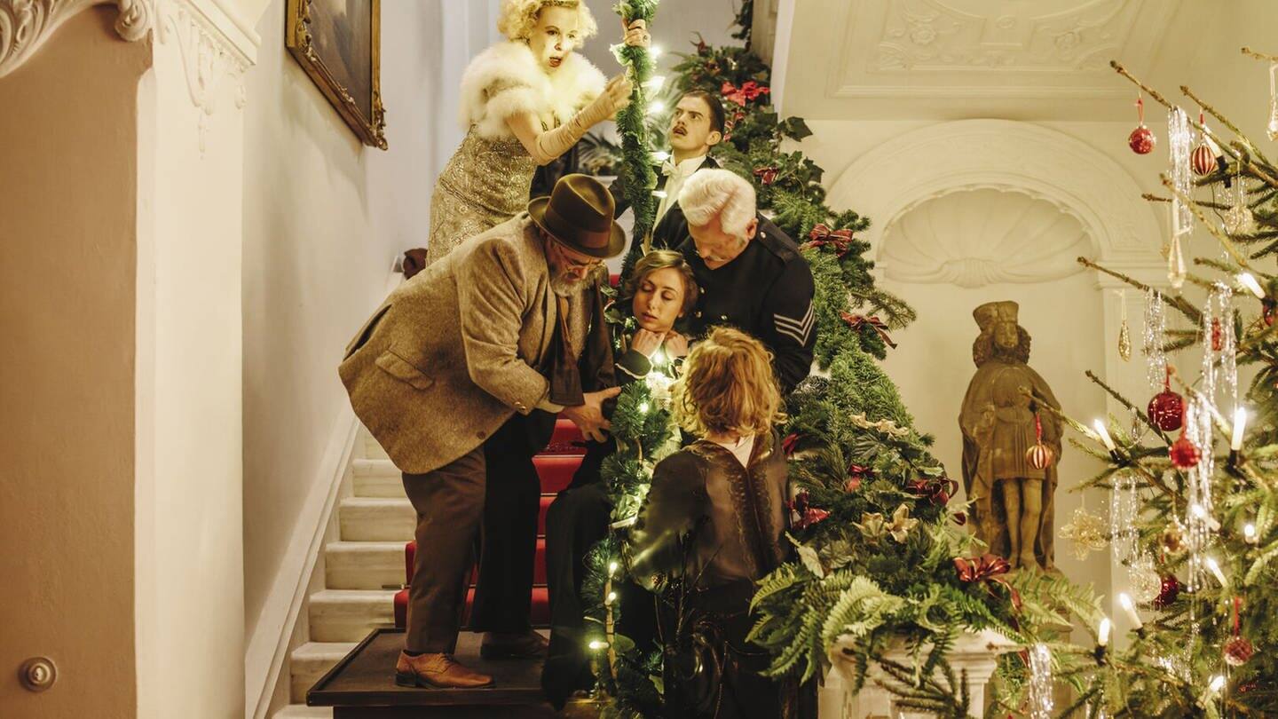 5 Menschen auf einer Treppe, die weihnachtlich dekoriert ist (Foto: ard-foto s2-intern/extern, BR/Bavaria Fiction GmbH/Hendrik Heiden)