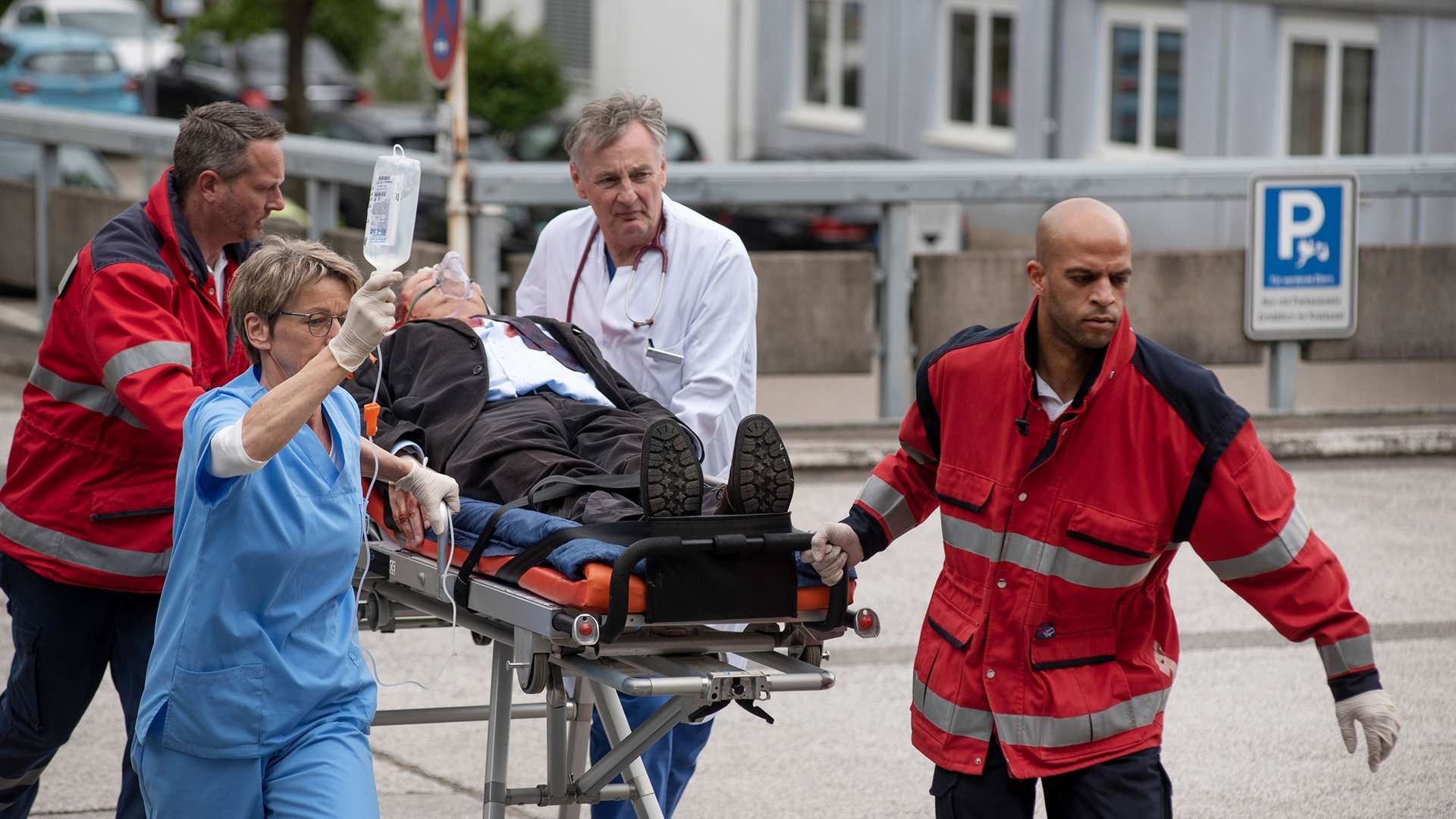 Foto: ard-foto s2-intern/extern, NDR / ARD / Thorsten Jander Im Tatort Kiel wird Borowski auf einer Krankentrage liegend von vier Sanitätern begleitet geschoben (Foto: ard-foto s2-intern/extern, NDR / ARD / Thorsten Jander)
