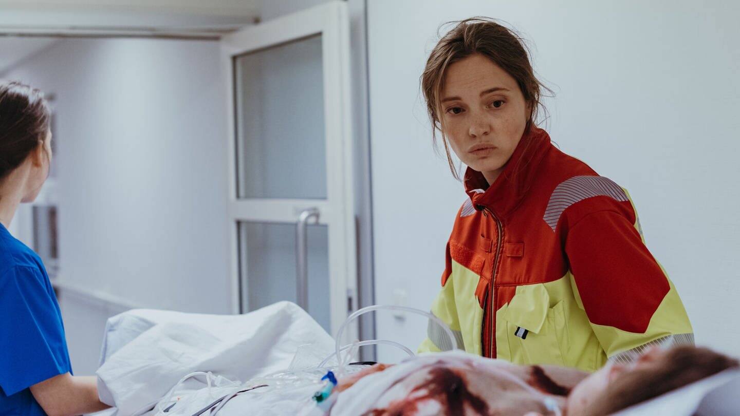 Eine Rettungssanitäterin schiebt eine Patientin durch eine Tür im Krankenhaus beim Polizeiruf 110 (Foto: BR/Amalia Film und Dragonbird Films/Sabine Finger)