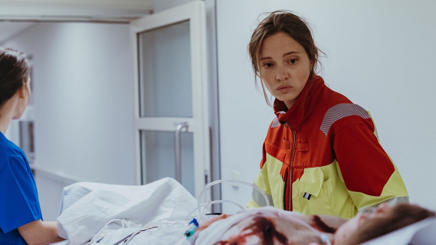 Foto: BR/Amalia Film und Dragonbird Films/Sabine Finger Eine Rettungssanitäterin schiebt eine Patientin durch eine Tür im Krankenhaus beim Polizeiruf 110 (Foto: BR/Amalia Film und Dragonbird Films/Sabine Finger)