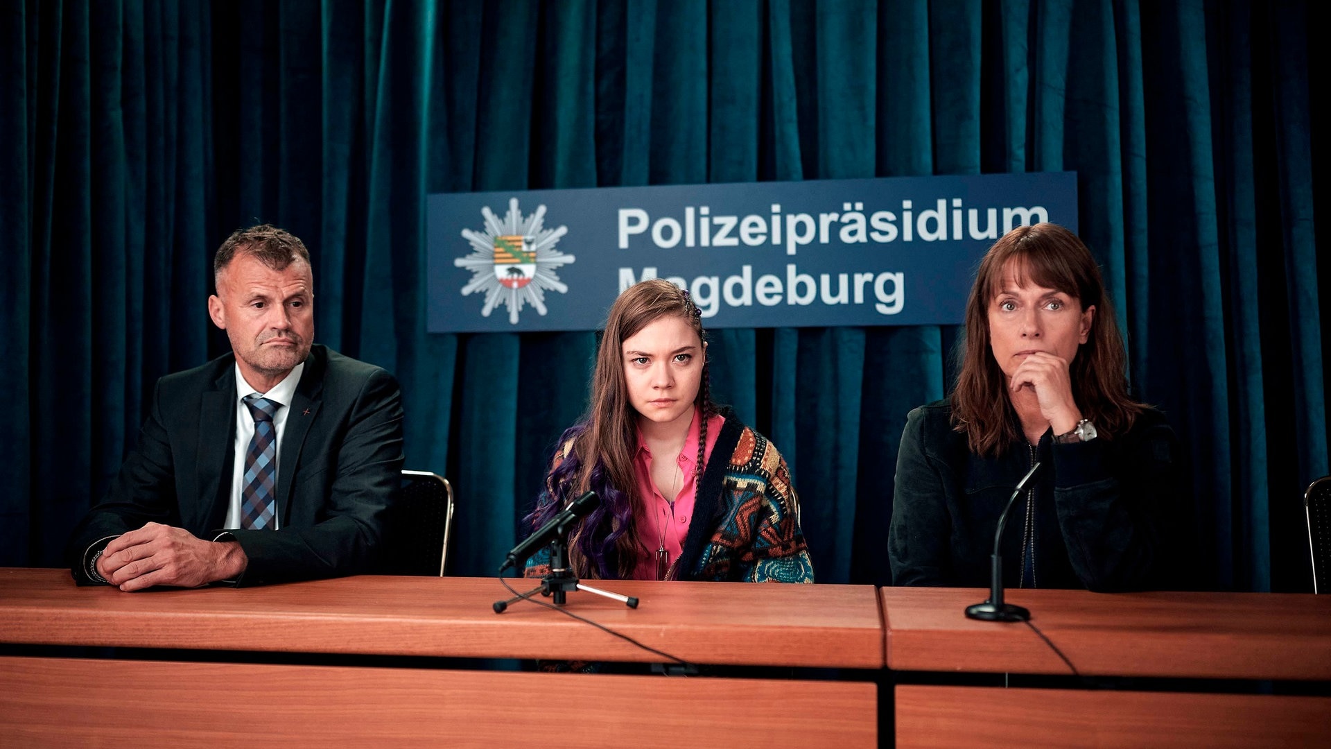 Foto: ard-foto s2-intern/extern, MDR / Felix Abraham Polizeiruf-Kritik Magdeburg: Lana Stokowsky und Doreen Brasch vor Mikrofonen bei der Pressekonferenz. Im Hintergrund ein Schild mit Aufschrift Polizeipräsidium Magdeburg. (Foto: ard-foto s2-intern/extern, MDR / Felix Abraham)