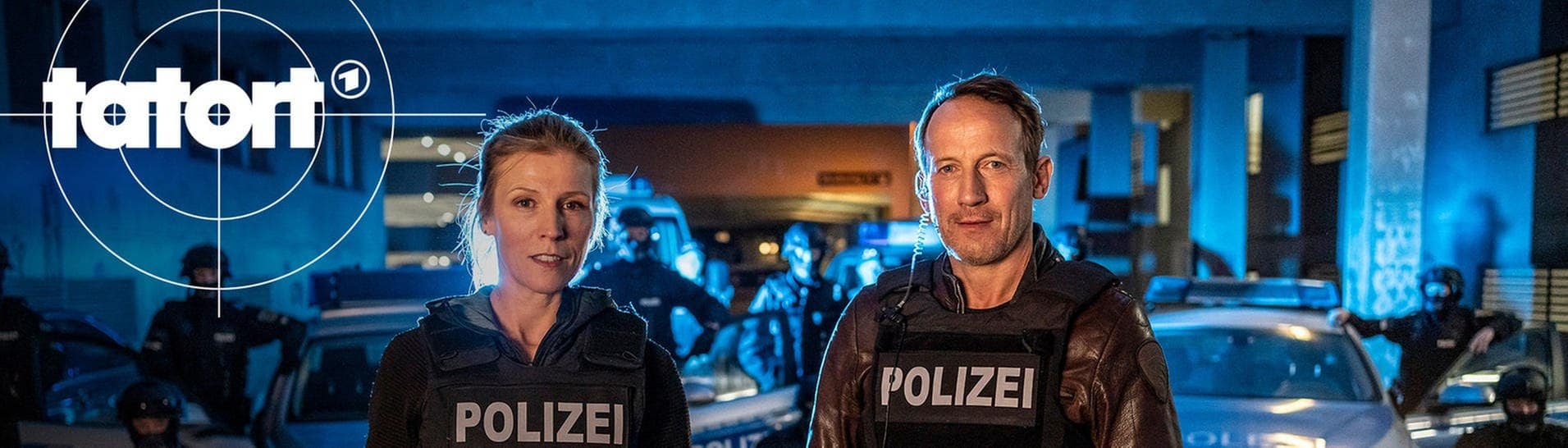 Julia Grosz und Thorsten Falke stehen in Einsatzkleidung nachts vor Polizeiautos und dem SEK (Foto: ard-foto s2-intern/extern, NDR / Georges Pauly)