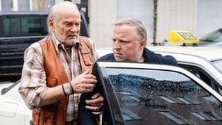 Kommissar Frank Thiel (Axel Prahl, r) unterwegs zum Tatort: Sein Vater Herbert (Claus D. Clausnitzer, l) muss ihm aus dem Taxi helfen, denn der Ermittler leidet unter Rückenschmerzen. (Foto: © WDR/Willi Weber) Kommissar Frank Thiel (Axel Prahl, r) unterwegs zum Tatort: Sein Vater Herbert (Claus D. Clausnitzer, l) muss ihm aus dem Taxi helfen, denn der Ermittler leidet unter Rückenschmerzen.