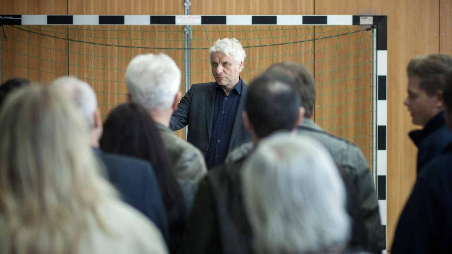 In einer Turnhalle hält Franz Leitmayr eine emotionale Ansprache vor seinen Kollegen. (Foto: BR/X Filme/Hagen Keller)