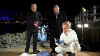Fundort Rheinufer: Hier wurde die Leiche des Export- und Finanzberaters Martin Lessnik angespült. Rechtsmedizinerin Schleiche diskutiert mit den Kommissaren Max Ballauf und Freddy Schenk. (Foto: WDR / Thomas Kost) Fundort Rheinufer: Hier wurde die Leiche des Export- und Finanzberaters Martin Lessnik angespült. Rechtsmedizinerin Schleiche diskutiert mit den Kommissaren Max Ballauf und Freddy Schenk.