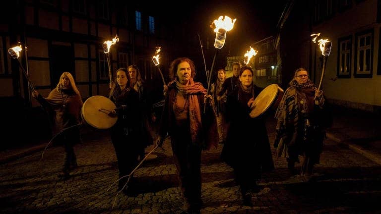Frauen laufen in der Dunkelheit mit Fackeln, Trommeln und Waffen durch ein Dorf (Foto: ard-foto s2-intern/extern, MDR / filmpool fiction / Conny Klein)