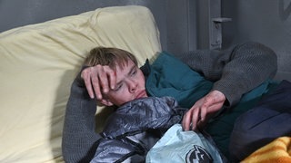 Mann liegt auf alter Matratze 
