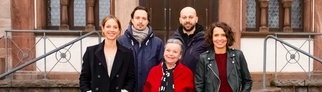 Cast vom Tatort "Lenas Tante" vor dem Drehstart auf einer Treppe vor einem Haus. 