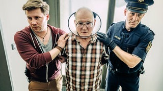 Hackl wird von zwei Polizisten abgeführt (Foto: ard-foto s2-intern/extern, BR / Tellux Film GmbH / Hendrik Heiden) Hackl wird von zwei Polizisten abgeführt