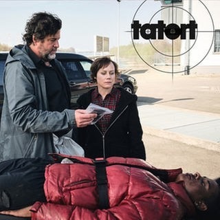 Tatort Schwarzwald: Tobler und Berg untersuchen die Sachen des Toten im Hintergrund warten die Bestatter