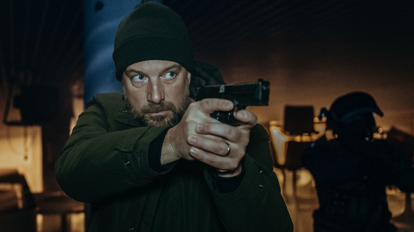 Dennis Eder, der Kommissar im Polizeiruf 110, steht mit der Waffe im Anschlag im Raum (Foto: BR/Amalia Film und Dragonbird Films/Sabine Finger)