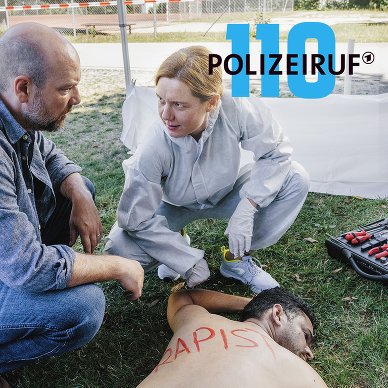 Polizeiruf-Kritik München: „Little Boxes“: Kriminalhauptkommissar Dennis Eden und Judith Flaman untersuchen den toten Dawoud Alrashid. (Foto: ard-foto s2-intern/extern, Ariane Krampe Filmproduktion/BR/Hendrik Heiden)