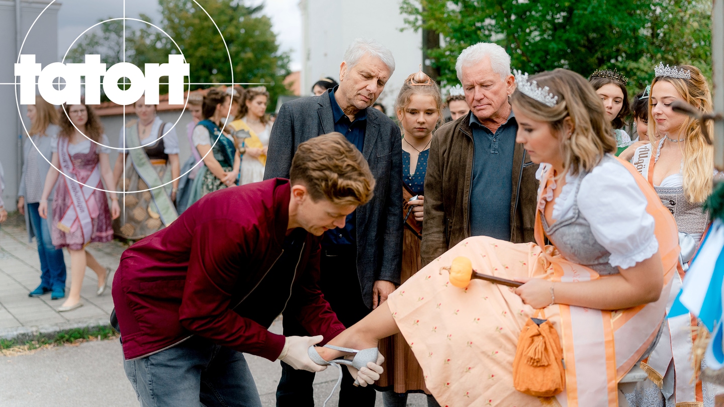 Tatort-Kritik München „Königinnen“: Kommissar Hammermann versucht einer Frau im Dirndl unter Beobachtung von Batic und Leitmayr einen Schuh anzuziehen. (Foto: ard-foto s2-intern/extern, BR / Odeon Fiction GmbH / Luis Zeno Kuhn)