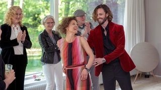 Tatort-Kritik „Borowski und der Wiedergänger“ aus Kiel: Menschen tanzen in einem noblen Wohnzimmer im Hintergrund applaudieren Leute (Foto: ard-foto s2-intern/extern, NDR / Thorsten Jander) Tatort-Kritik „Borowski und der Wiedergänger“ aus Kiel: Menschen tanzen in einem noblen Wohnzimmer im Hintergrund applaudieren Leute