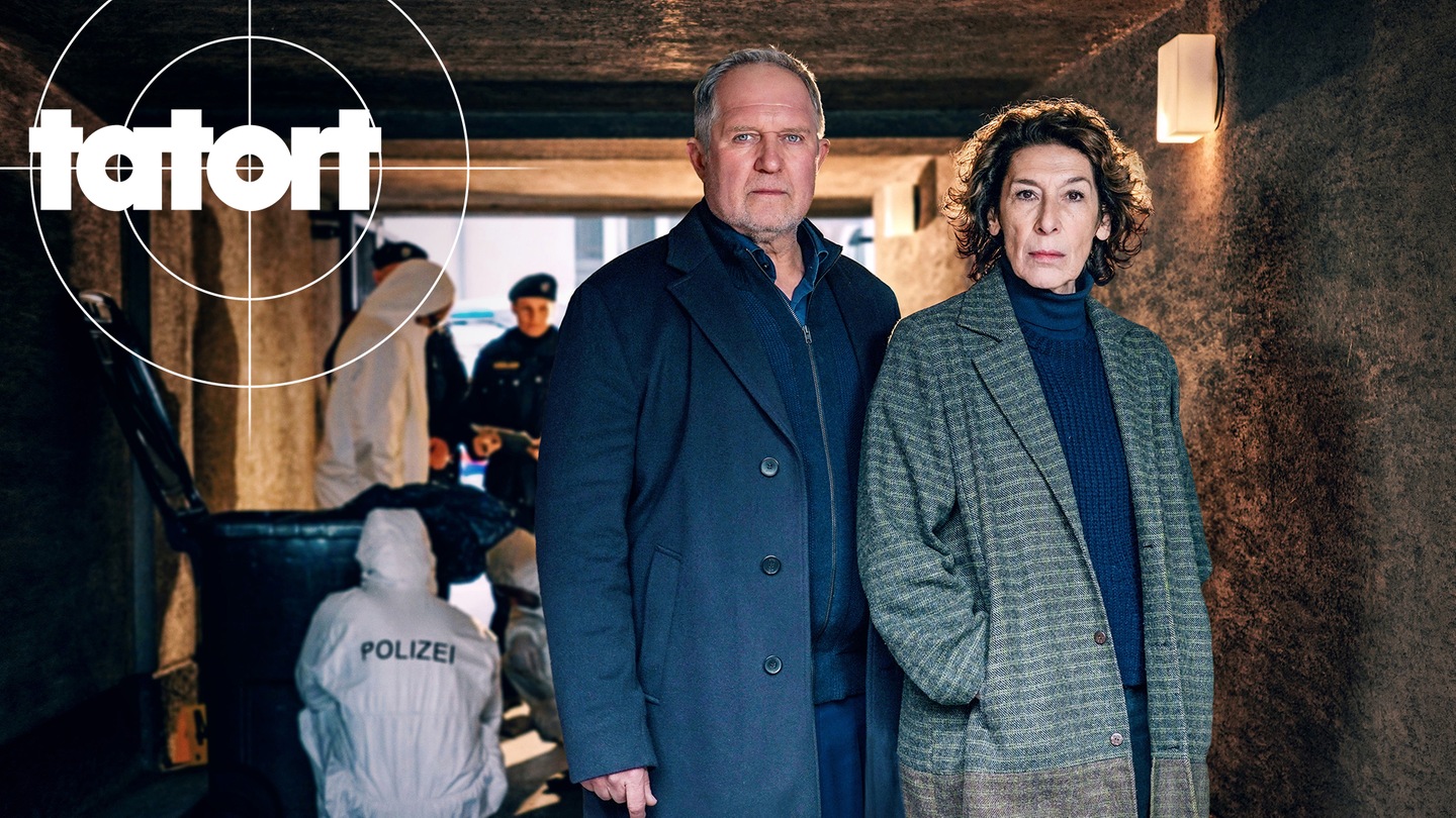 Tatort-Kritik Wien „Dein Verlust“: Die beiden Kommissare stehen fotogen vor einem Tatort. Im Hintergrund die Spurensicherung. (Foto: ard-foto s2-intern/extern, ORF / Petro Domenigg)