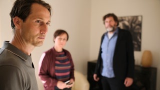 Tatort-Kritik „Letzter Ausflug Schauinsland“ Schwarzwald: Der Mann der Toten schaut bedrückt in eine Richtung, im Hintergrund stehen die Kommisare