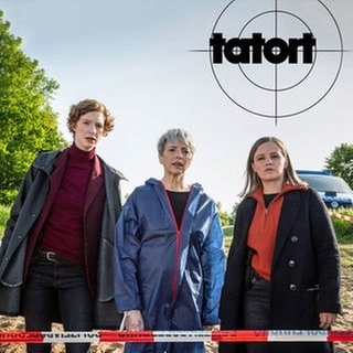 Szenenbild Tatort „Solange du atmest“ aus Bremen: Die Bremer Ermittlerinnen Linda Selb und Liv Moormann stehen mit der Gerichtsmedizinerin vor einem Absperrband am Tatort. 