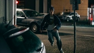 Szenenbild aus dem Tatort „Feuer“ aus Dortmund: Junger Mann rennt auf einer dunklen Straße an Autos vorbei. (Foto: ard-foto s2-intern/extern, WDR/Martin Rottenkolber) Szenenbild aus dem Tatort „Feuer“ aus Dortmund: Junger Mann rennt auf einer dunklen Straße an Autos vorbei.