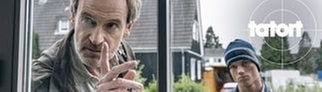 Szenenbild aus dem Tatort „Feuer“ aus Dortmund: Kommissar Faber schaut mit erhobenem Zeigefinger durch ein Fenster.