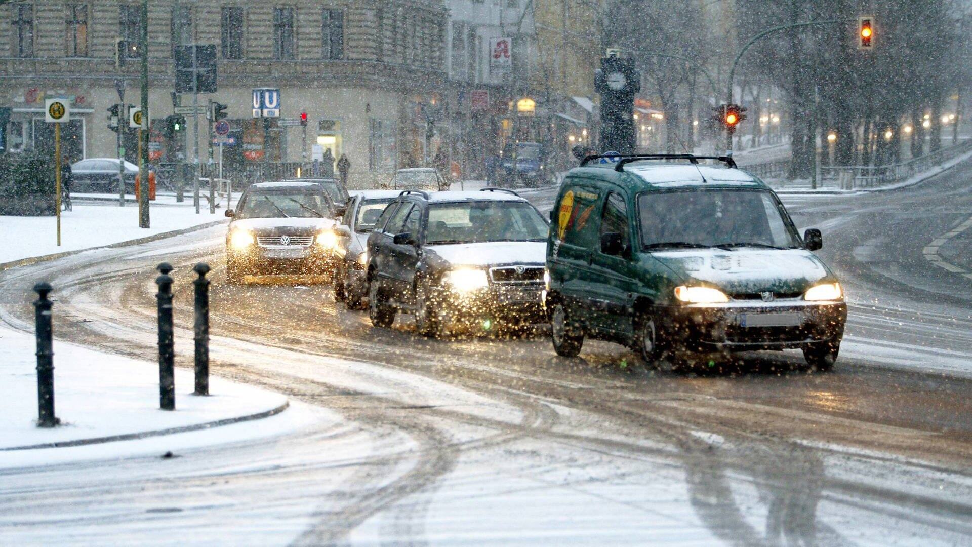 Mehrere Autos fahren bei Schnee im Stadtverkehr. (Foto: IMAGO, Contrast/Streubel)