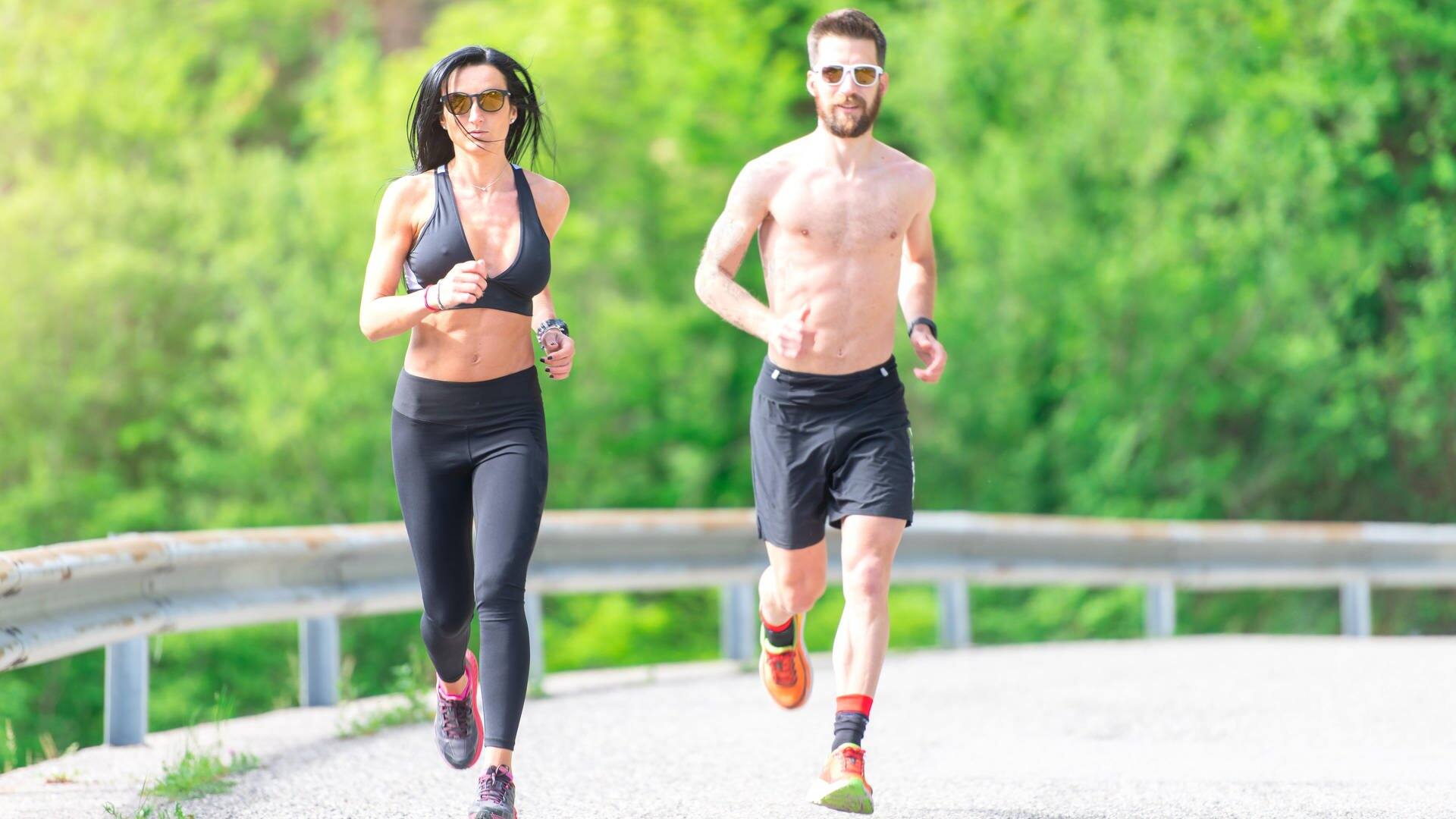 Ein Mann und eine Frau in Sportbekleidung joggen eine Straße entlang der Kamera entgegen. (Foto: picture-alliance / Reportdienste, picture alliance / CHROMORANGE | Michelangelo Oprandi)